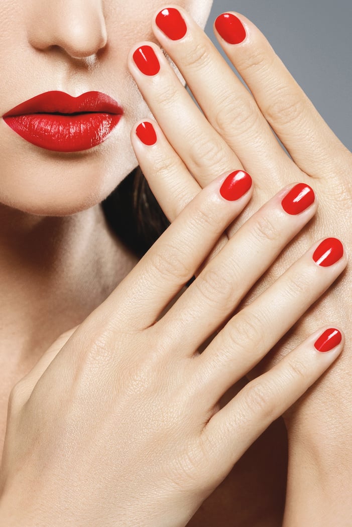 Close-up of Female Mouth and Nails with Red Manicure and Lipstic